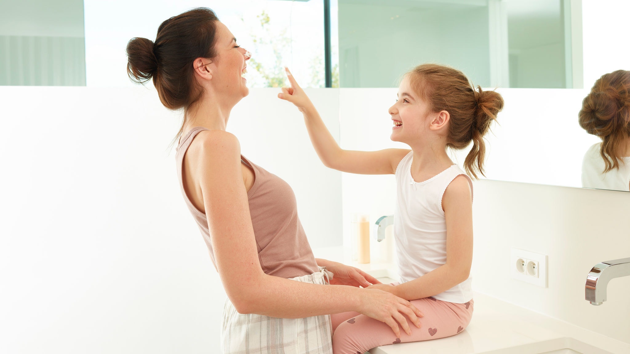 Mother and daughter playing around in the bathroom
