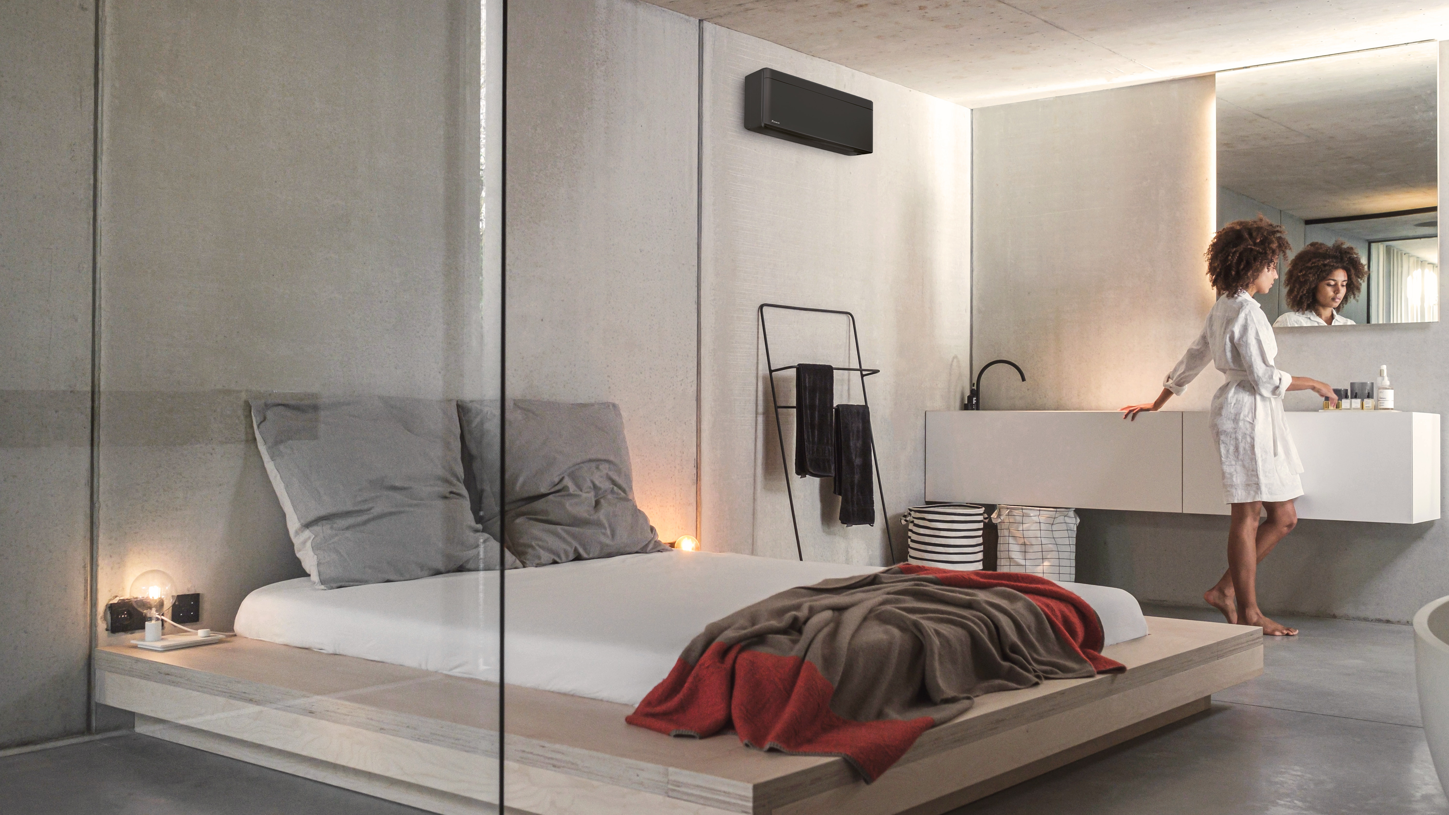 A woman getting ready for the day in her bedroom and integrated bathroom air conditioned and heated by a Stylish indoor unit